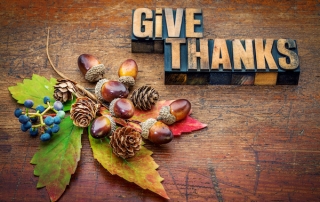 Give Thanks in typeset letters on wood background with autumn decorations, estate planning attorney advice