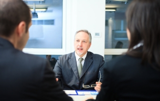 Man sitting at a desk talking to a couple, personal representative in florida probate