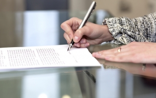 Close up of female hand signing formal paper