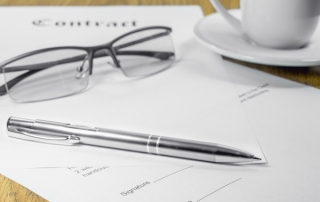 contract business papers pen glasses cup of coffee